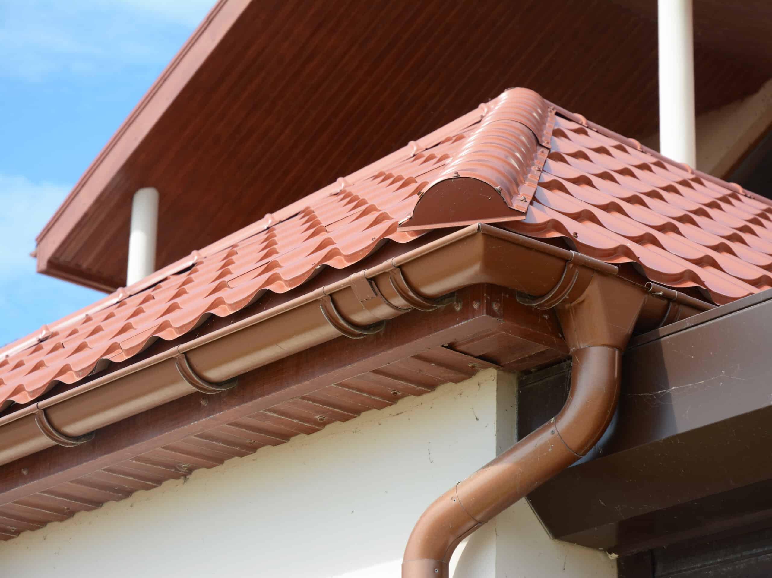 Close up view on House Metal Roof Problem Areas for Rain Gutter Waterproofing Outdoor. Home Guttering, Soffit, Fascia, Plastic Guttering System, Guttering & Drainage Pipe Exterior. Roofing repair.